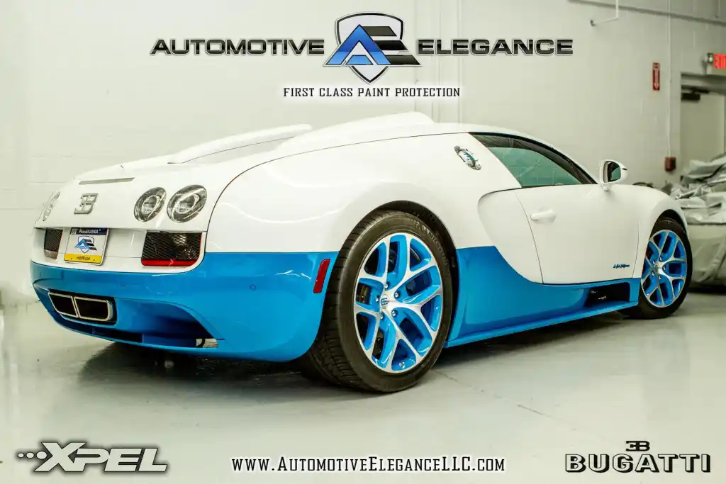 Rear three-quarter view of a white and blue Bugatti Veyron with blue alloy wheels
