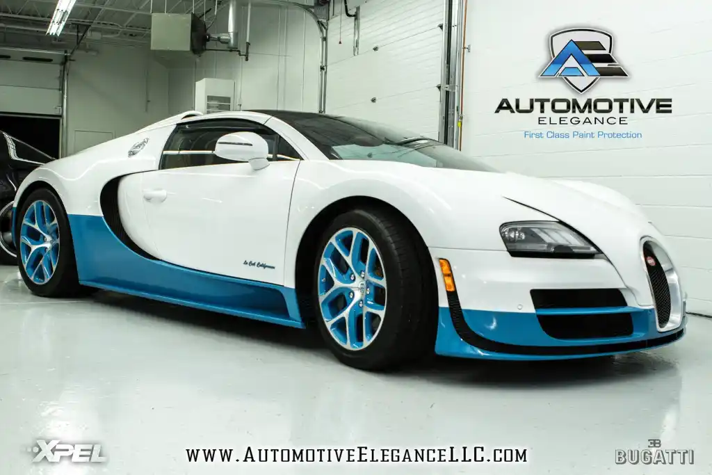 Front three-quarter view of a white and blue Bugatti Veyron in a showroom