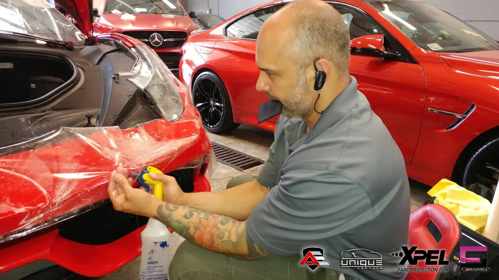 Technician aligning paint protection film on the front bumper of a Ferrari 458 Speciale