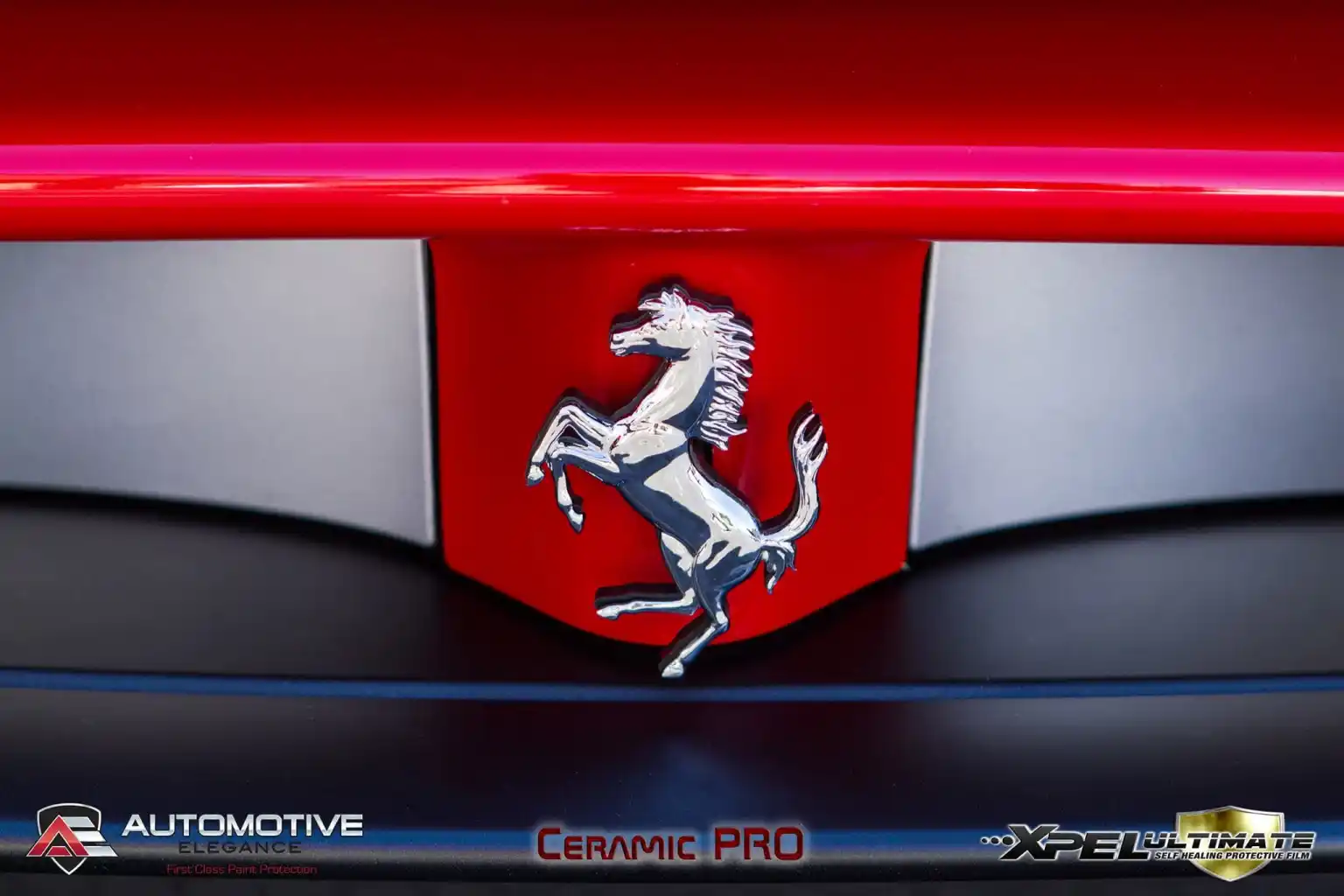 Close-up of Ferrari prancing horse emblem on a red front fascia