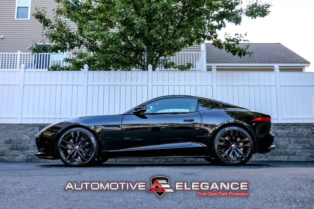 Black Jaguar F-TYPE R coupe parked on a residential street with gloss paint protection