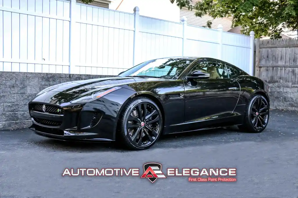 Front three-quarter view of a black Jaguar F-TYPE R coupe parked outdoors