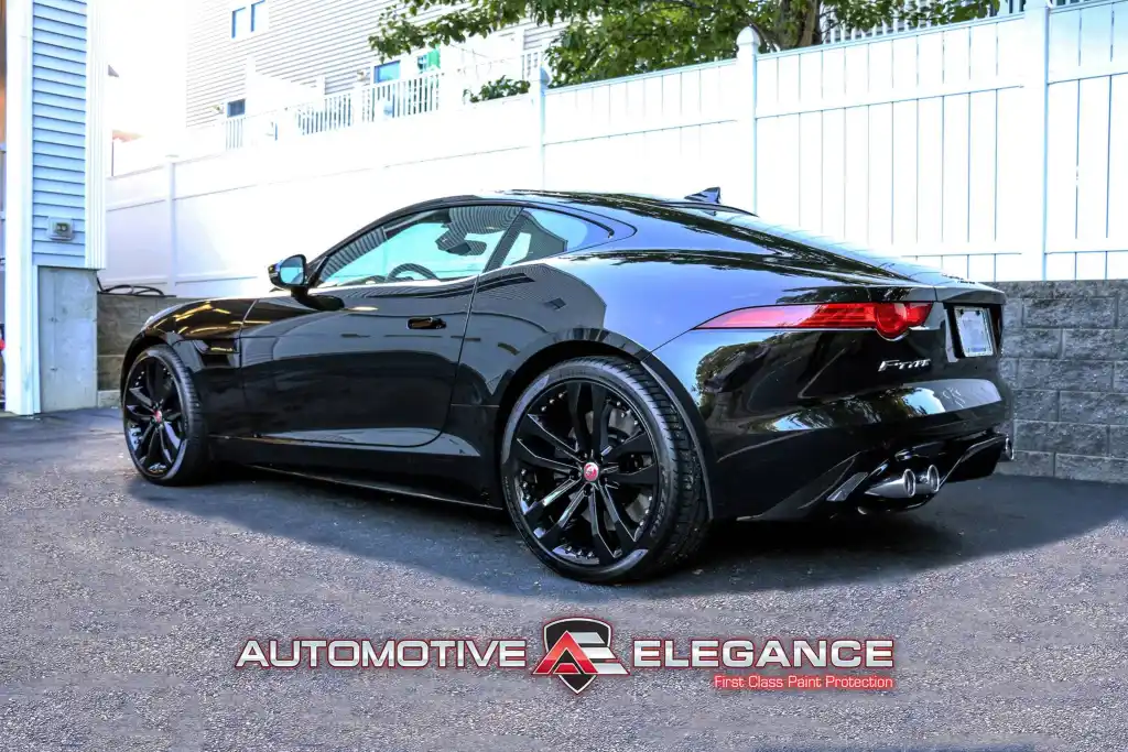 Rear three-quarter view of a black Jaguar F-TYPE R with glossy paint finish