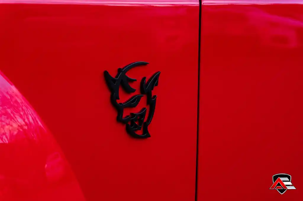 Close-up of the Dodge Demon badge on a red front fender