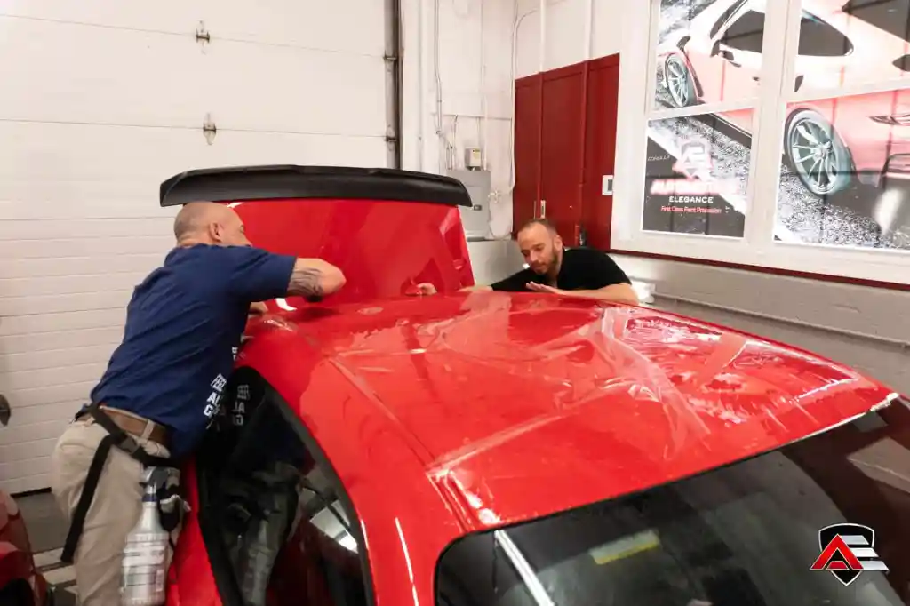 Paint protection film being applied to the roof of a red Dodge Challenger Demon