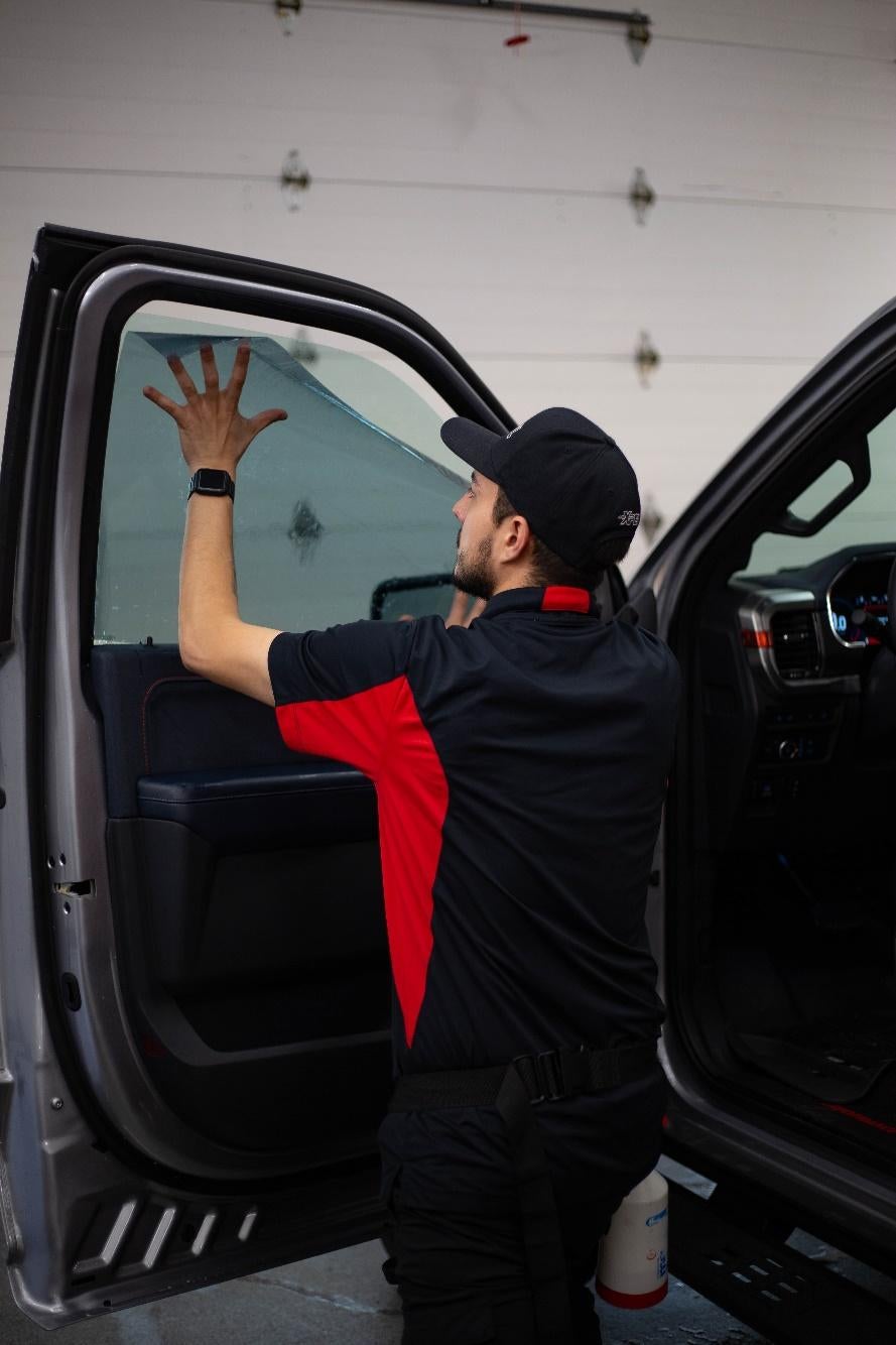 Daniel laying the tint film on the window