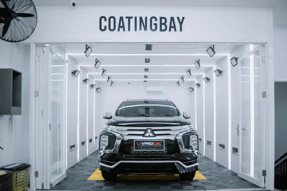 A black SUV in a brightly lit car coating bay with COATINGBAY written overhead.