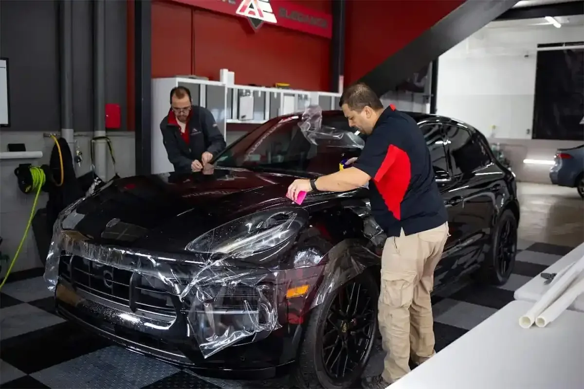 Two men wrapping a car