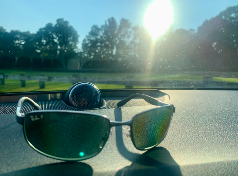 Sunglasses on a car dashboard in bright sunlight