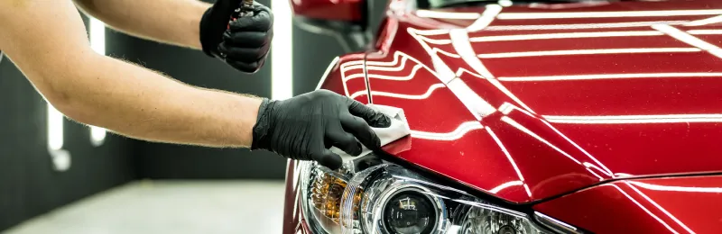 Car service worker applying nano coating on a car detail.